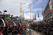 816302 Gezicht in de fietsenstalling op het Jaarbeursplein te Utrecht, met op de achtergrond het in aanbouw zijnde ...